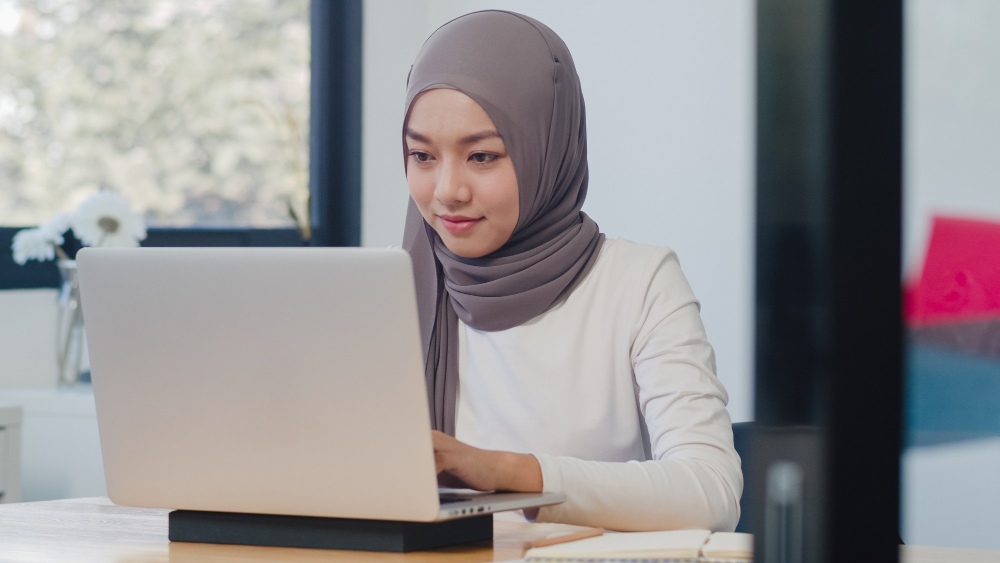 kobi education-lpdp 2024 tahap 1-gambar wanita hijab sedang mengetik di laptop warna putih
