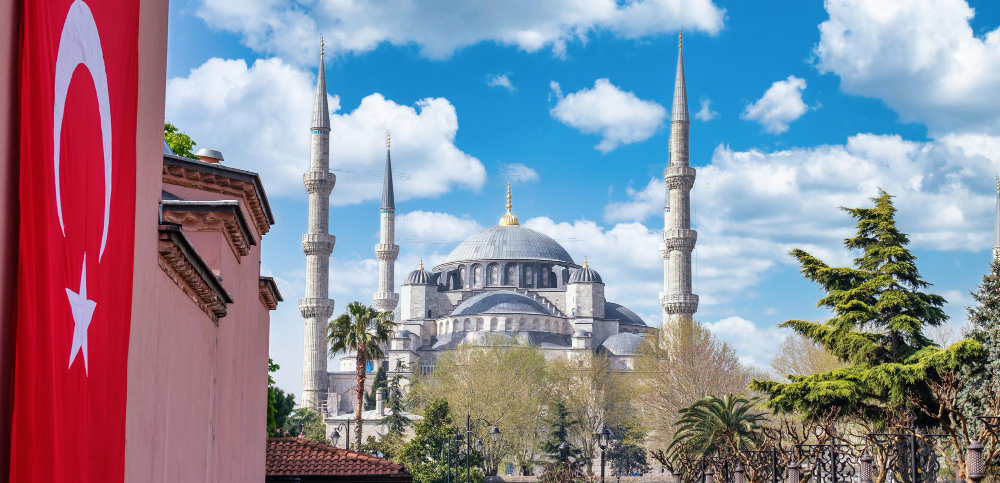 kobi education-turkiye burslari scholarship 2024-gambar masjid di siang hari beserta bendera turki
