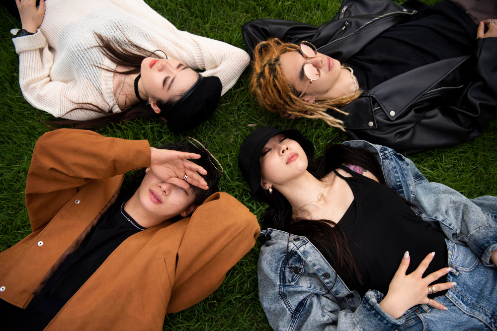 kobi education-artis kpop terkenal-gambar para artis kpop sedang bersantai di atas rumput tanah