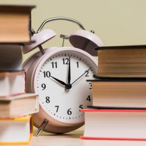 kobi education-deadline lpdp tahap 2-gambar jam alarm di tengah tumpukan buku