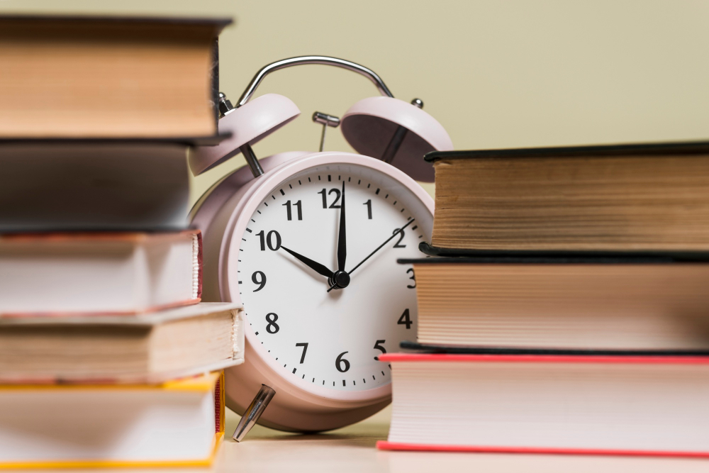kobi education-deadline lpdp tahap 2-gambar jam alarm di tengah tumpukan buku