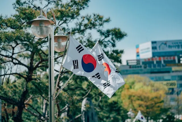 kobi education-cara kuliah gratis ke korea selatan-gambar bendera korea selatan yang sedang berkibar di tengah kota