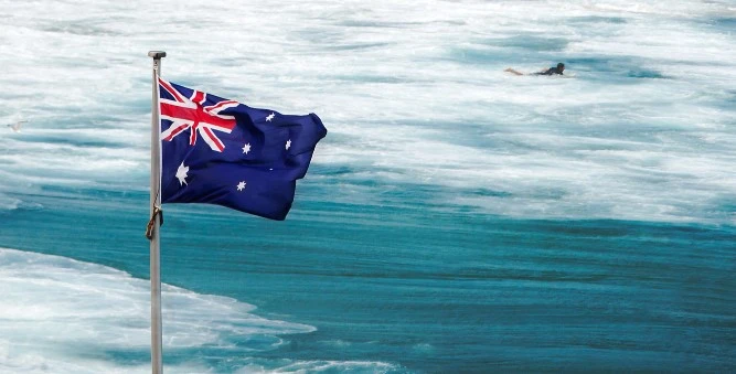 kobi education-universitas australia terbaik-gambar bendera australia sedang berkibar di dekat pantai