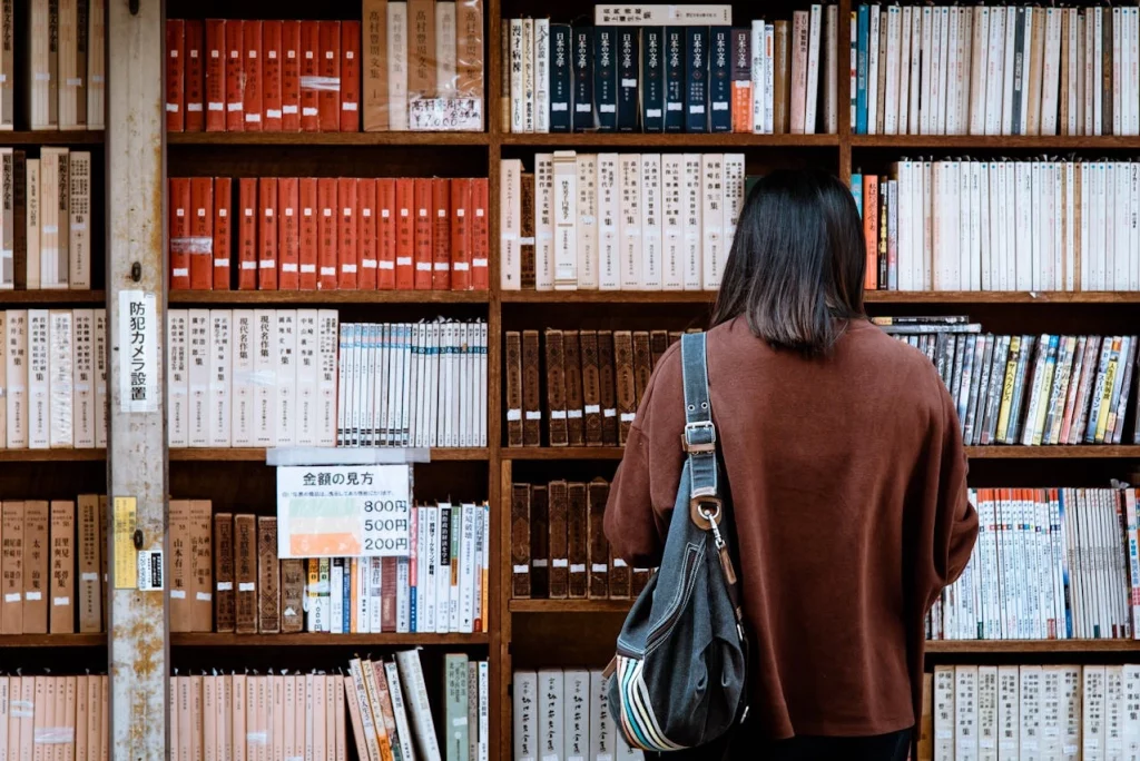 kobi education-cara kuliah s1 di luar negeri-gambar perempuan sedang membaca buku di perpustakaan terbuka