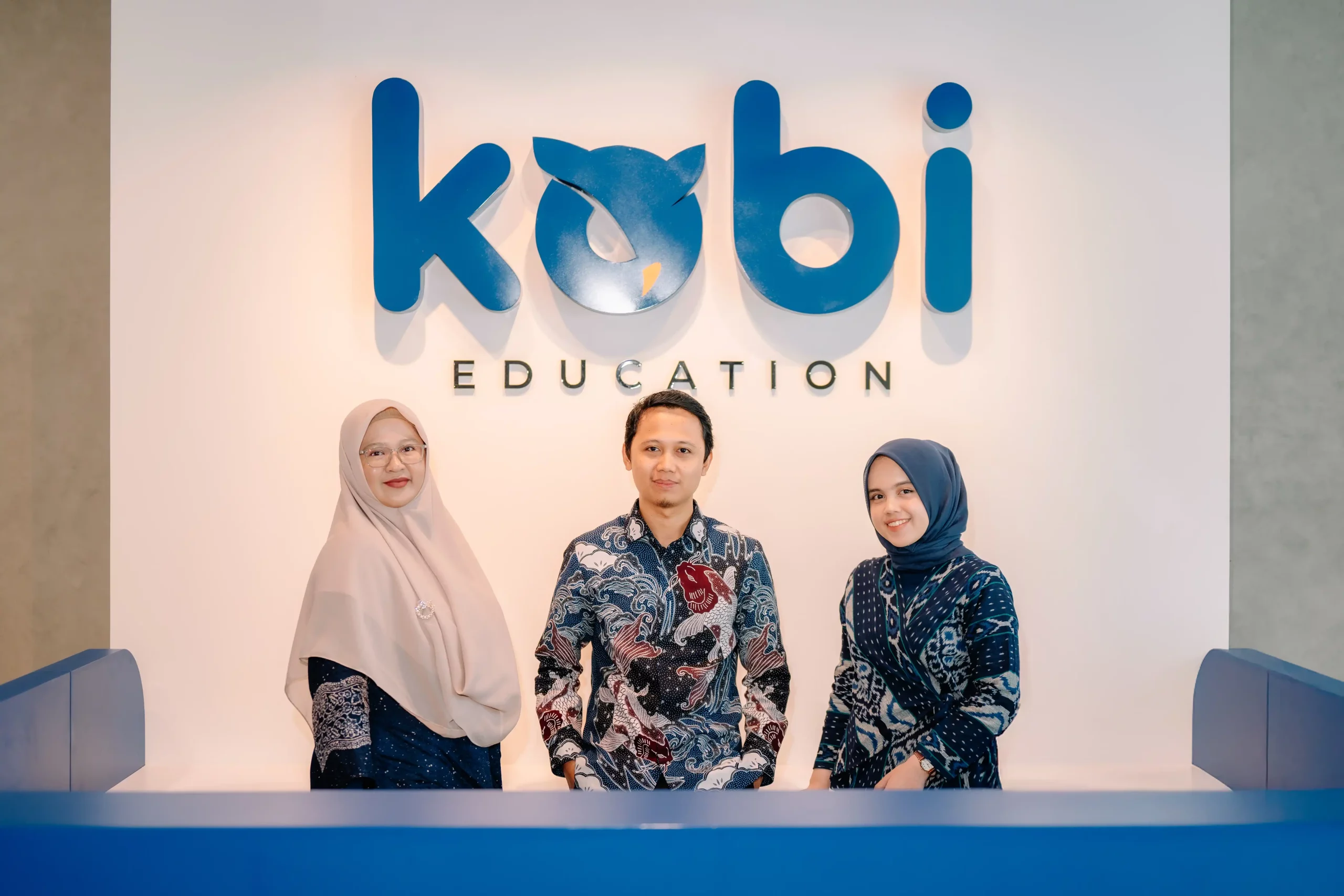 kobi education-grand opening kobi-gambar tiga pegawai kobi sedang berfoto bersama