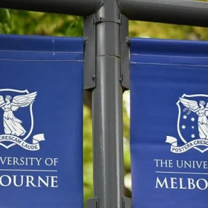 kobi education-jurusan di melbourne university-gambar bendera university of melbourne di tengah taman