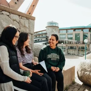 kobi education-unbc international scholars program-gambar tiga mahasiswi sedang berbincang mengenai topik pembelajaran dari kelas kuliah yang telah mereka ikuti