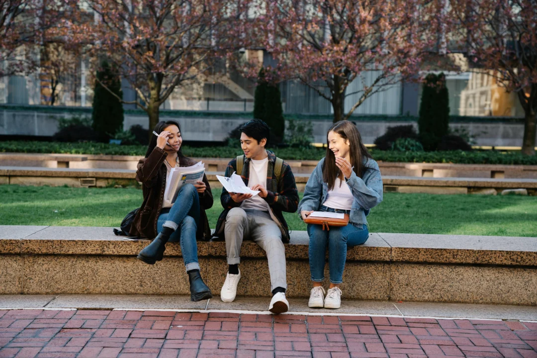 kobi education-perbedaan university dan college buat s1 di amerika-gambar tiga kerabat sedang membahas mengenai projek kuliah dengan tema sosial