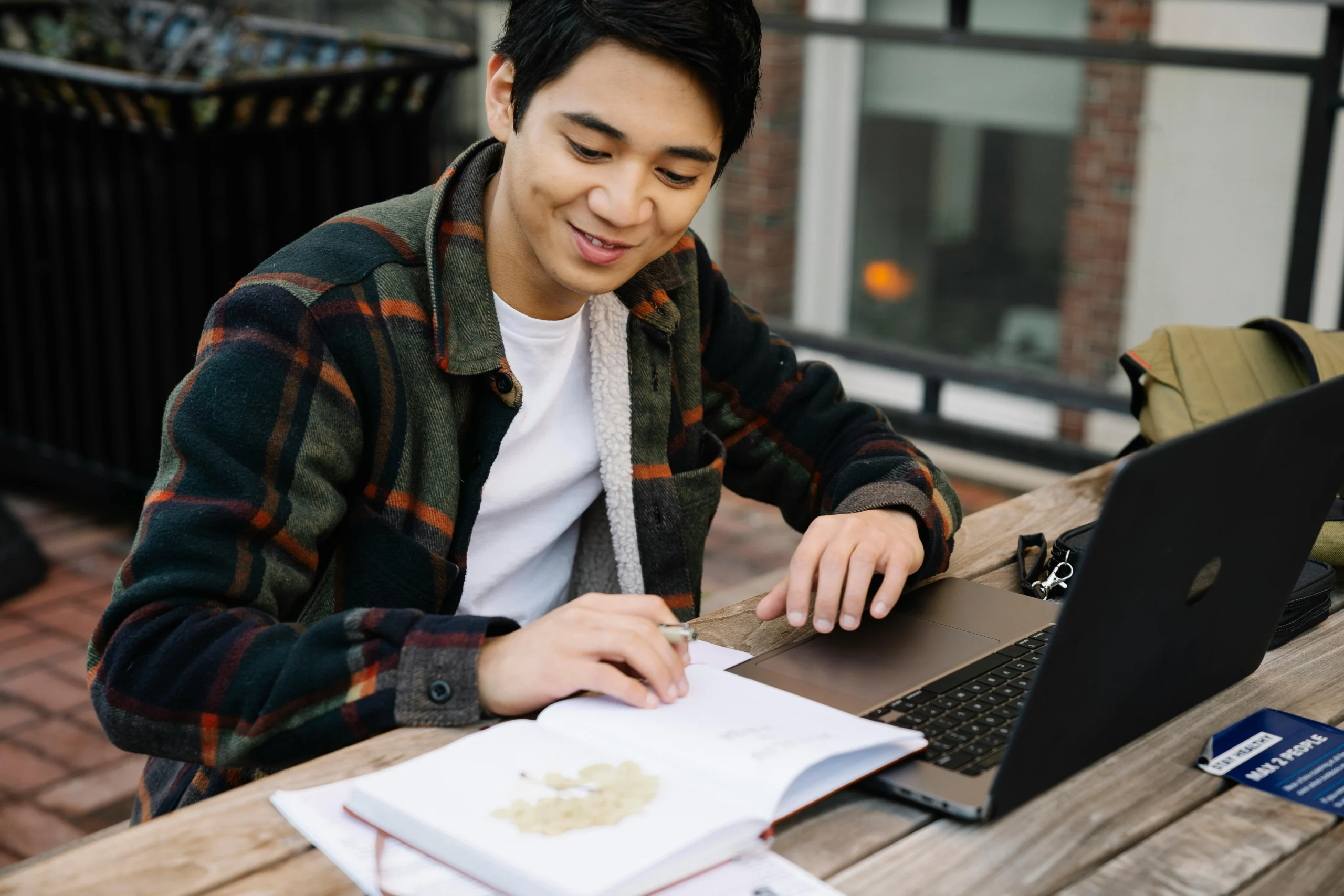 kobi education-beasiswa luar negeri buat s1 tanpa ipk tinggi-gambar seseorang sedang tersenyum ketika sedang belajar di tempat publik