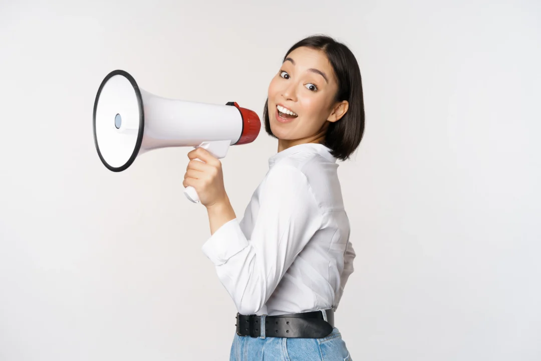 kobi education-daftar idiom yang pas ketika digunakan pada saat ielts speaking-gambar perempuan sedang berbicara melalui megaphone dengan sangat gembira