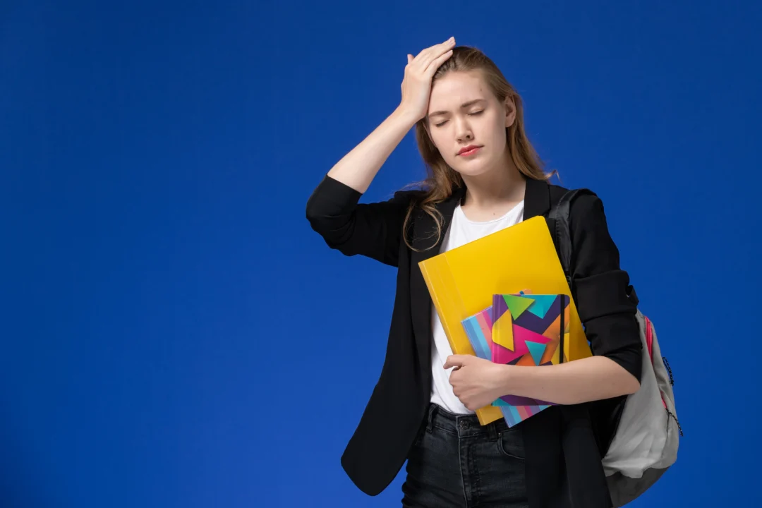 kobi education-cara memilih jalur lpdp-gambar perempuan sedang pusing dalam menghadapi pekerjaannya dengan background biru dibelakangnya