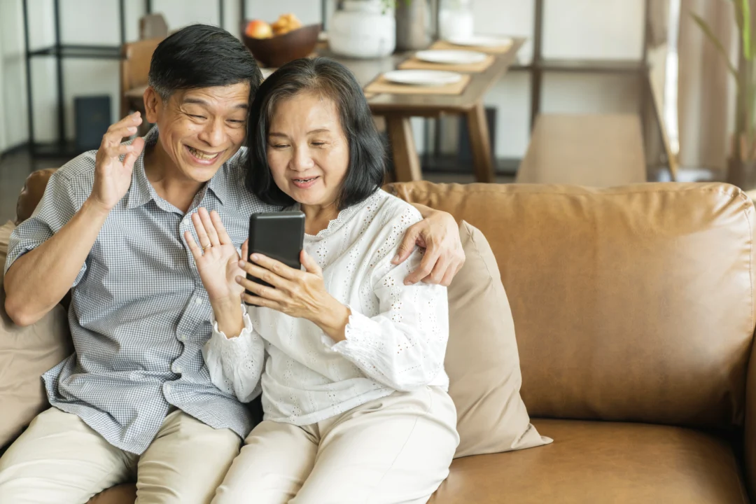 kobi education-aplikasi buat orang tua pantau kondisi anak ketika study abroad-gambar orang tua sedang berkomunikasi dengan anak via smartphone