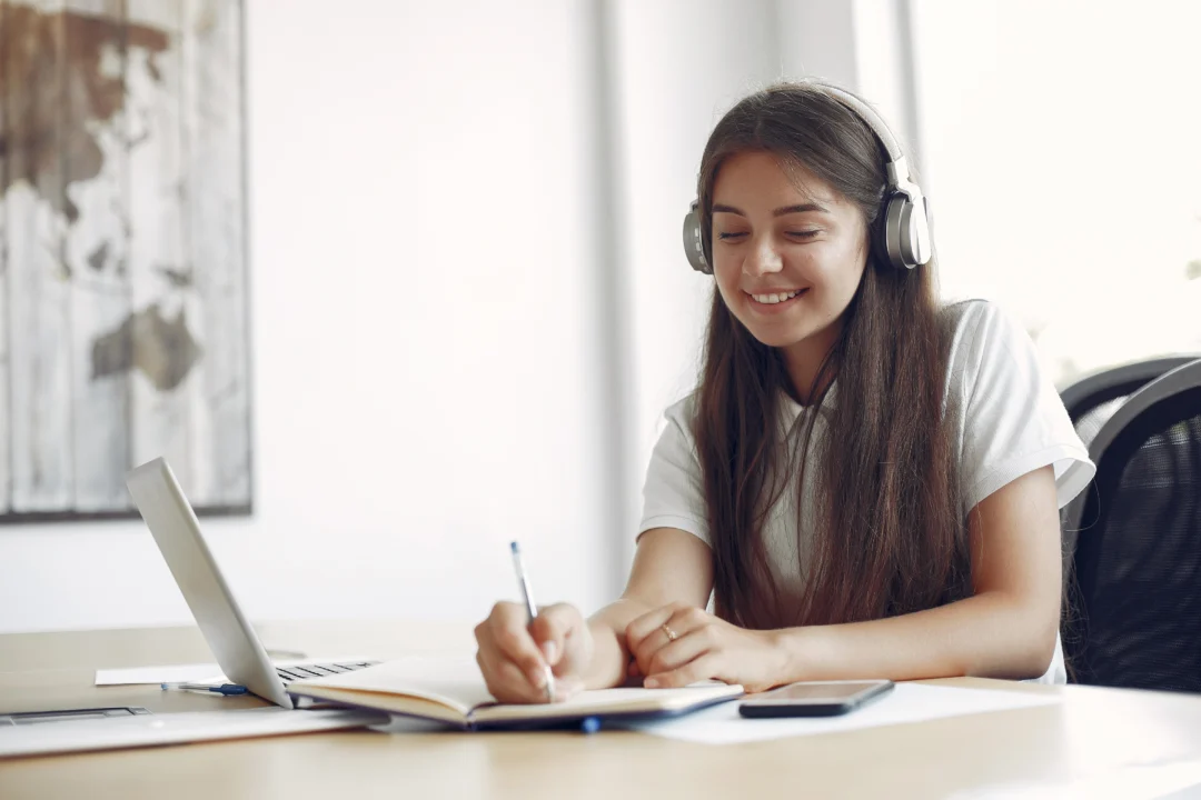 kobie education-cara mengejar ketertinggalan persiapan kuliah luar negeri di kelas 11-gambar siswa sedang belajar dengan gembira ketika menggunakan headphones di ruangnya sendiri