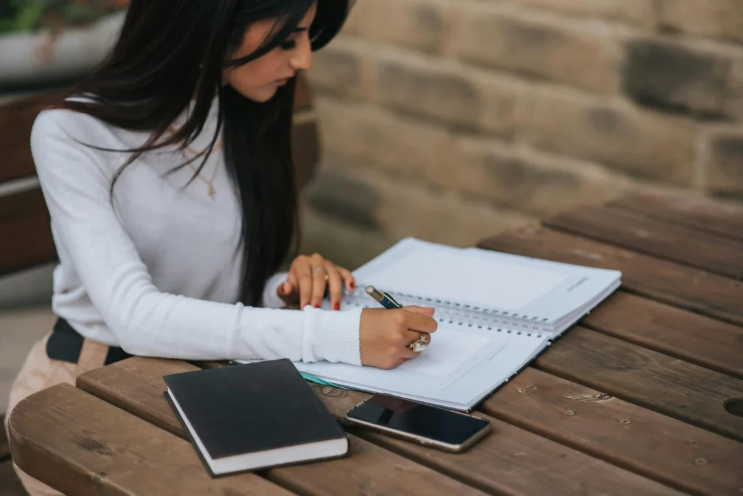 kobi education-beasiswa s1 belanda-gambar seorang perempuan sedang serius menulis catatan di jurnal bukunya