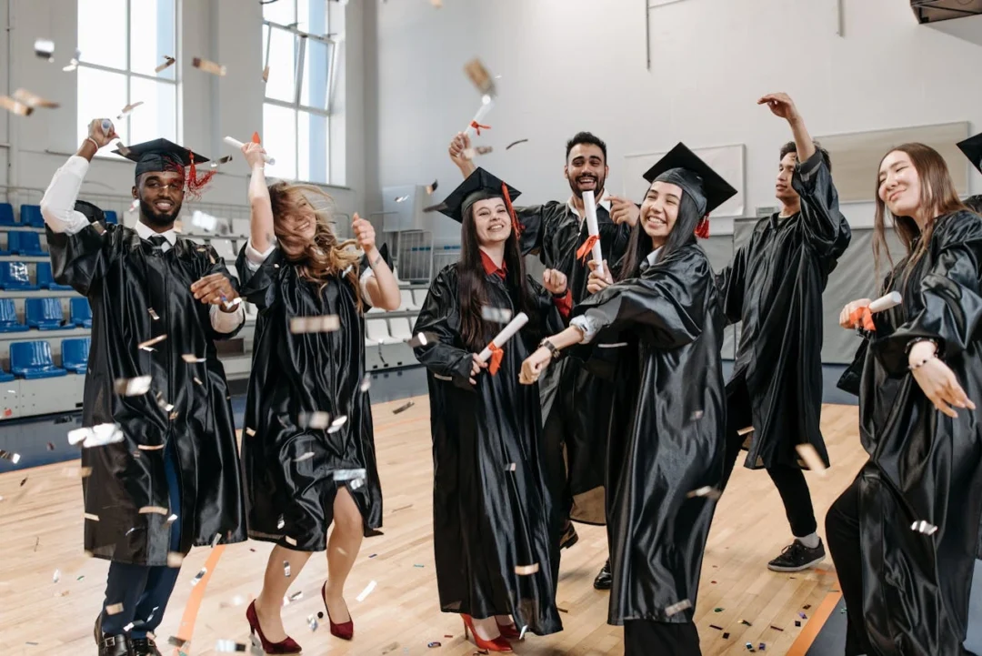 kobi education-beasiswa s2 luar negeri fully funded tanpa toefl-gambar para wisudawan yang sedang bergembira bersama di tengah lapangan bola basket kampus
