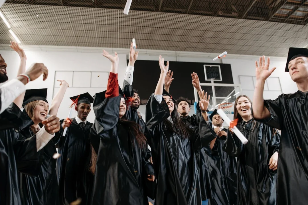kobi education-beasiswa luar negeri yang buka di januari-gambar berbagai mahasiswa yang telah menjadi wisudawan sedang melemparkan topi toga mereka dengan penuh keceriaan