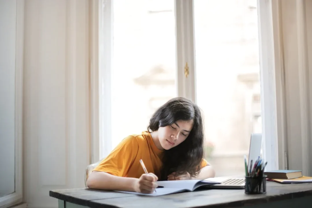 kobi education-kesalahan essay lpdp-gambar perempuan sedang belajar dengan ceria di ruang tamu yang cukup cerah nuansanya