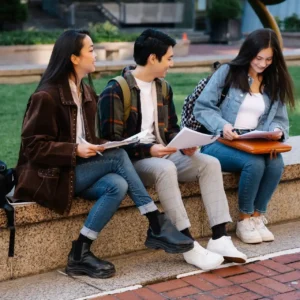 kobi education-tips memilih universitas luar negeri-gambar tiga mahasiswa internasional yang sedang duduk bersama dan membahas mengenai projek yang mereka kerjakan